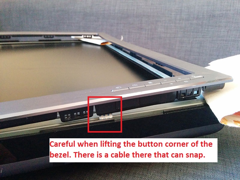 Careful not to snap the wire going to the front buttons when lifting the bezel